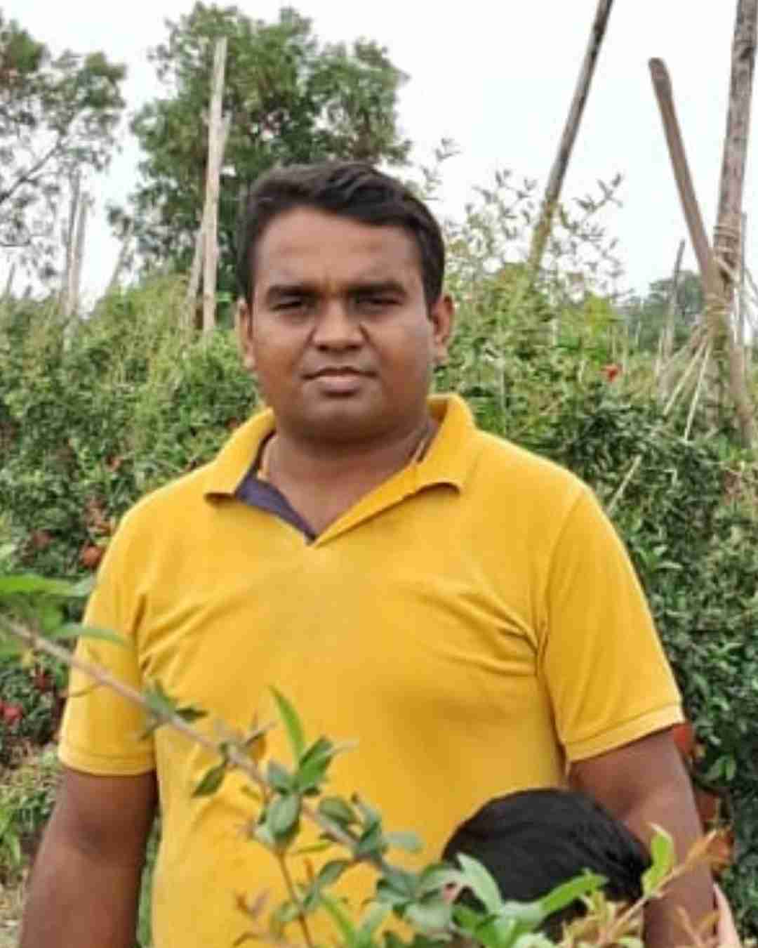 A young apple grower holding fresh red apples in Himachal Pradesh.